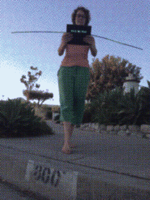 person walking on a wire with a tablet